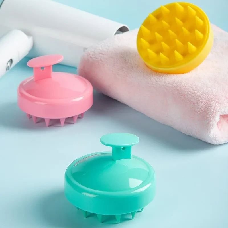 Escova de silicone para massagem capilar nas cores amarelo, rosa e verde com toalha rosa e secador