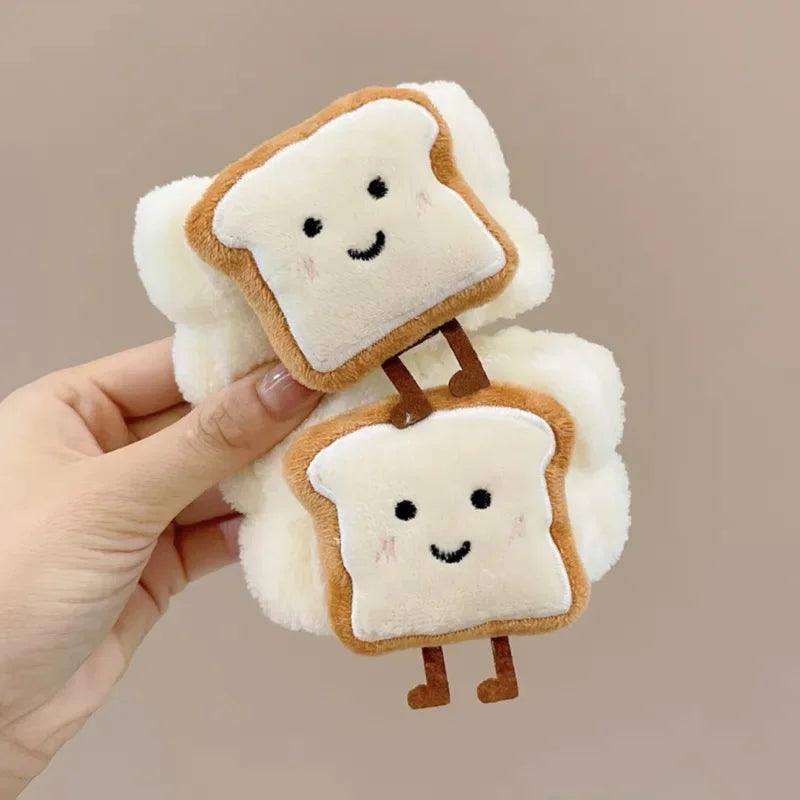 Mão segurando acessório de pelúcia com fatias de pão sorridentes e fofas